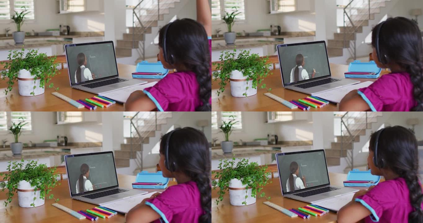 混血女孩坐在桌子上使用笔记本电脑上在线学校课程