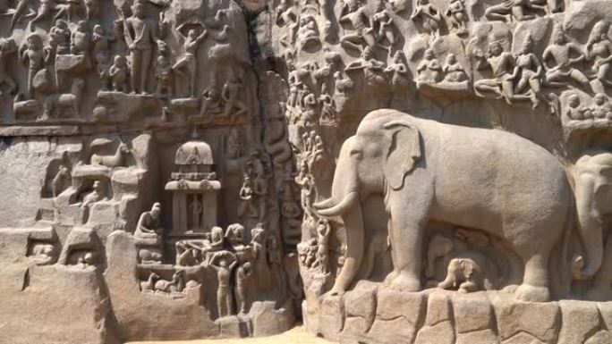 在泰米尔纳德邦Mahabalipuram的整体式露天岩石板上雕刻的印度教神，人和大象的历史雕塑的古代