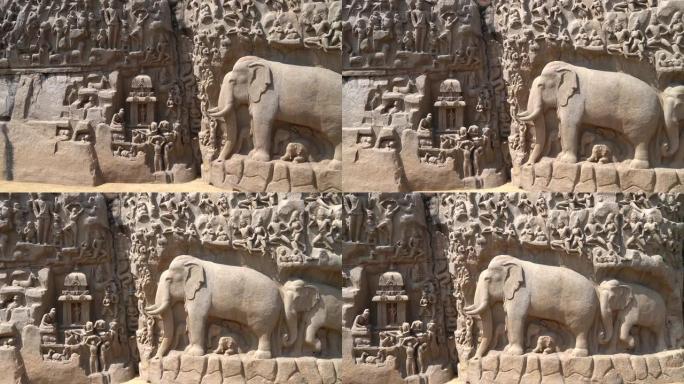 在泰米尔纳德邦Mahabalipuram的整体式露天岩石板上雕刻的印度教神，人和大象的历史雕塑的古代