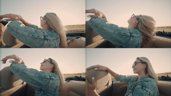 戴着墨镜的快乐年轻金发女郎骑着敞篷车，在日落的背景下举手迎风。在没有车顶的汽车中享受生活的女人的肖像