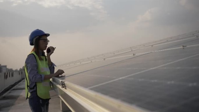 亚洲女工程师检查安装太阳能电池板。