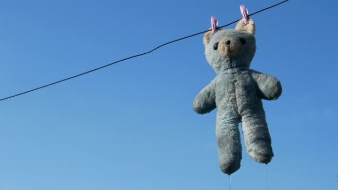 洗完衣服后，一只泰迪熊挂在晾衣绳上
