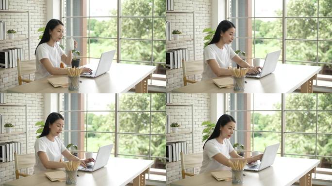 亚洲妇女在家使用笔记本电脑，在家工作
