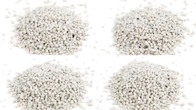由聚丙烯制成的次级颗粒，白色塑料颗粒在孤立的背景上崩溃。工业用颗粒塑料原料。聚合物树脂。生塑料回收概