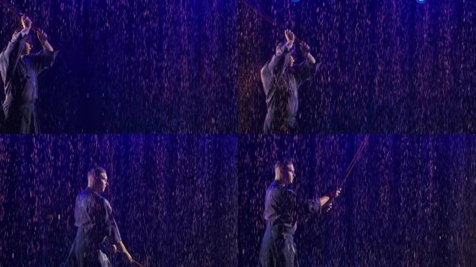 日本剑道战士穿着传统和服，在蓝光黑暗工作室背景下的雨滴中练习武术。男子通过挥杆神井练习战斗打击。特写