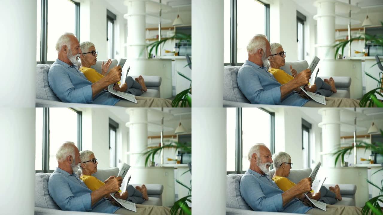 成熟的夫妇阅读杂志和交谈。