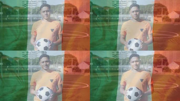爱尔兰国旗挥舞着在草地上拿着足球的男足球运动员的肖像