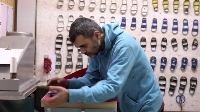 现代鞋匠在他的车间里使用切割机从皮革上切割儿童鞋的零件