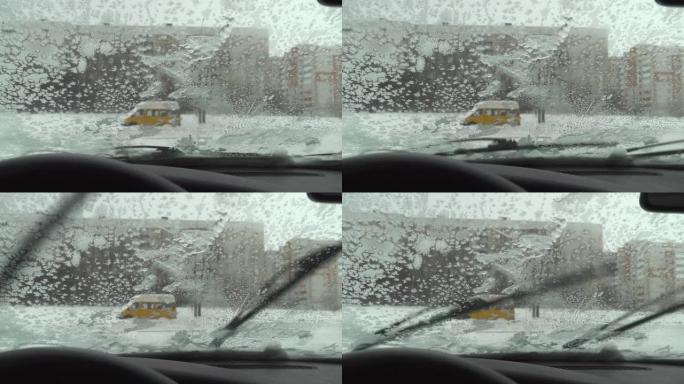 汽车挡风玻璃刷在冰冻的冰雪上滑动。凝析油。