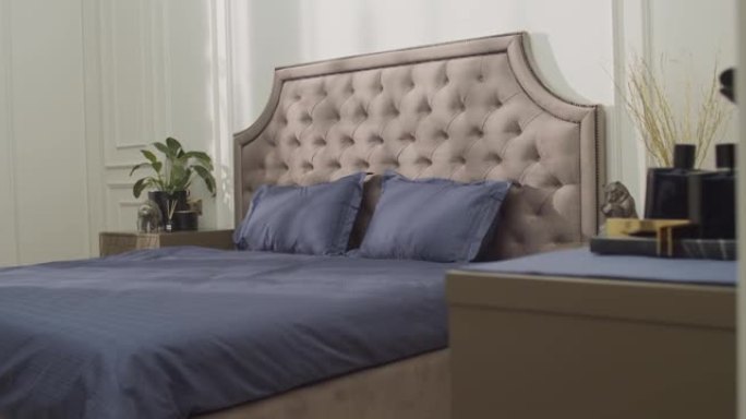 相机放大大灰色软垫双人床，上面配有紫色亚麻布