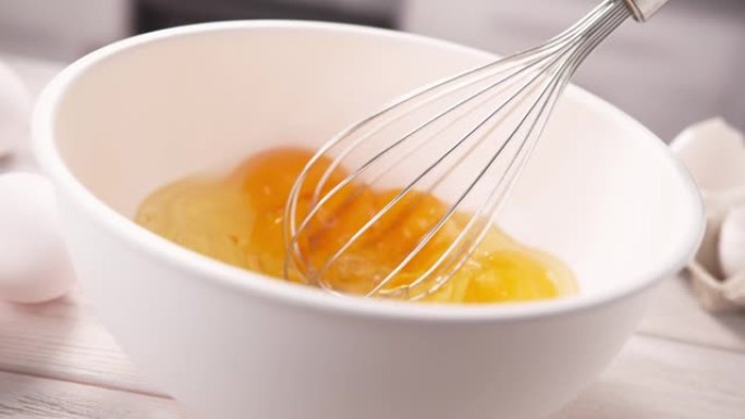 用打蛋器在白碗中搅拌整个鸡蛋作为蛋糕或煎蛋，慢动作