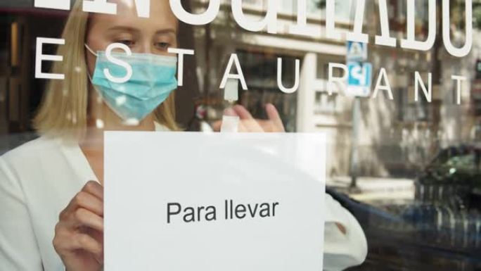 咖啡馆或餐馆和企业在冠状病毒检疫结束后重新开放。戴口罩的女人只能在门店上签字。covid封锁后的小企