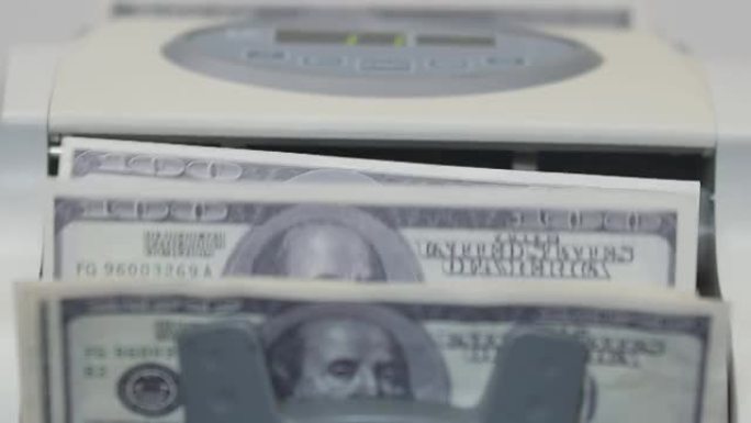 百元纸币在机器中进行记帐纸币的计数，特写。计数机计数许多美元钞票。经济学和货币的概念