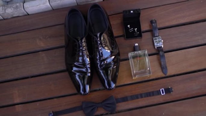 漆面男鞋，腕表，香水，袖扣，木制背景上的领结