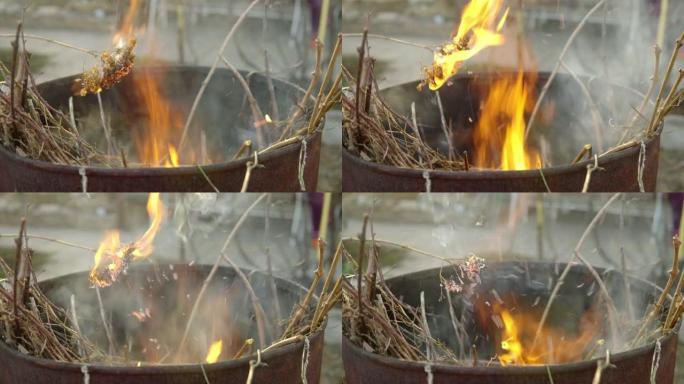 干草在一桶燃烧的碎屑上燃烧