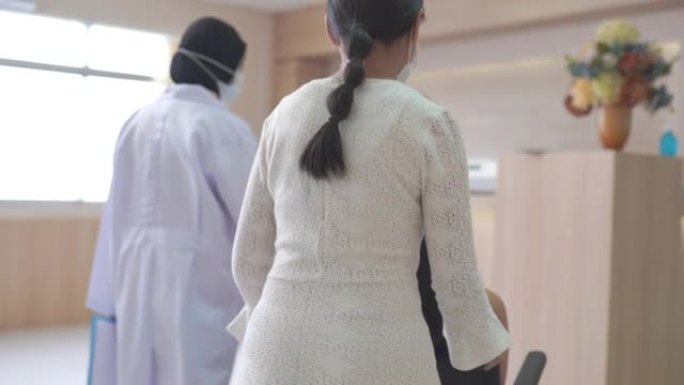 在医院大厅里，年轻夫妇的病人与接待员交谈
