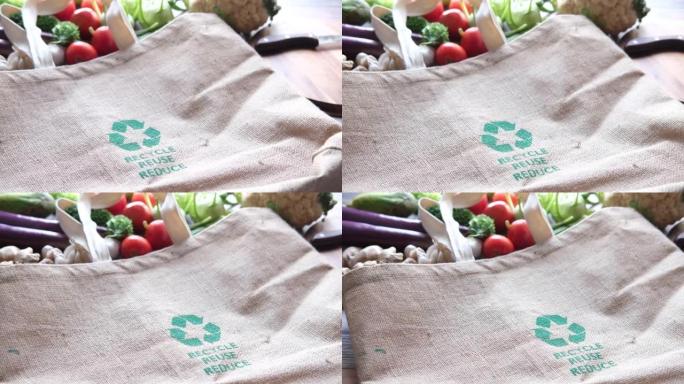 可重复使用的购物袋，桌子上有回收箭头标志和蔬菜