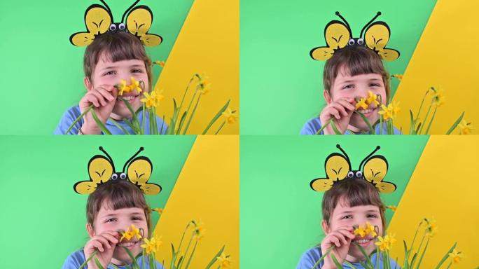 一个小女孩躲在绿色背景下的黄色水仙花后面。戴蜂帽的快乐孩子拿着一盆花园花。春天在花园里种植季节。选择