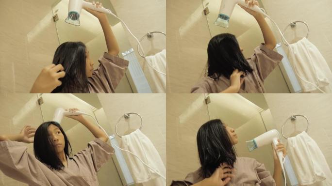 快乐的亚洲人穿着浴袍，在度假期间与家人一起在酒店的房间里吹干头发，生活方式理念。