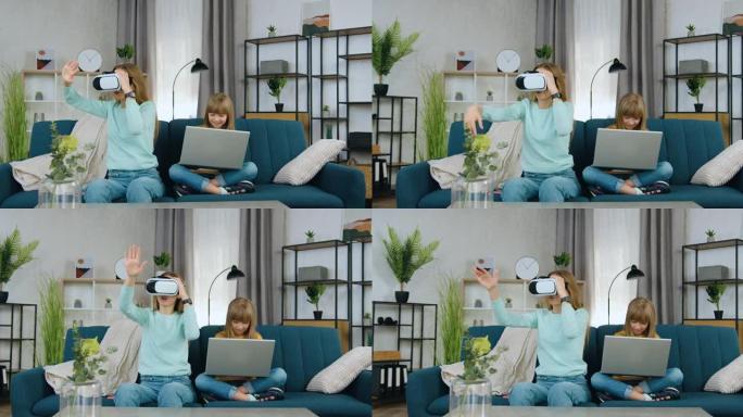 美丽积极的现代两个不同年龄的女孩共同休闲玩虚拟游戏使用笔记本电脑和增强现实护目镜，前视图