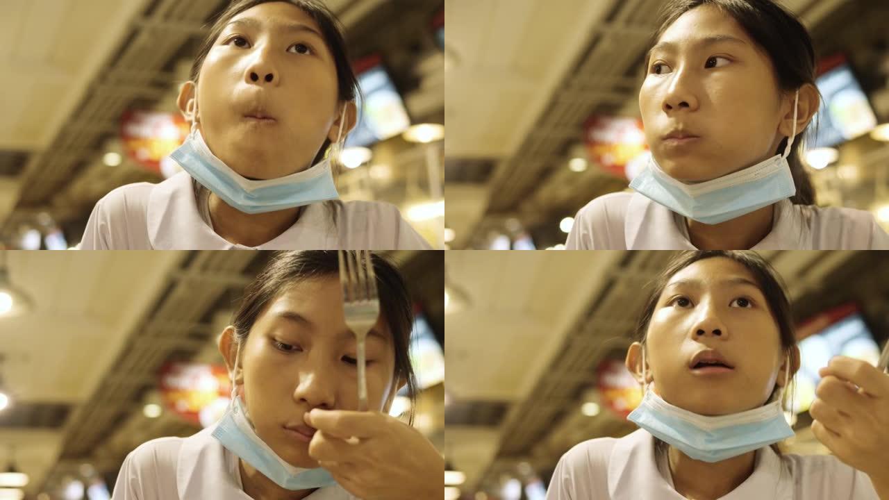 亚洲女学生穿着制服，和哥哥一起在美食广场吃面条汤，生活方式理念。