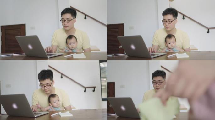 泰国父亲抱着婴儿女儿在家工作