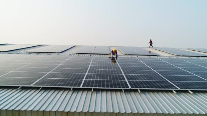 太阳能电池板技术员的空中拍摄，钻机在屋顶上安装太阳能电池板