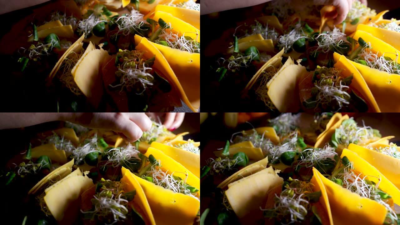 Macro在三明治上关闭了配料，其中包含大豆芽鲑鱼和奶酪，由女性的手准备作为零食。
