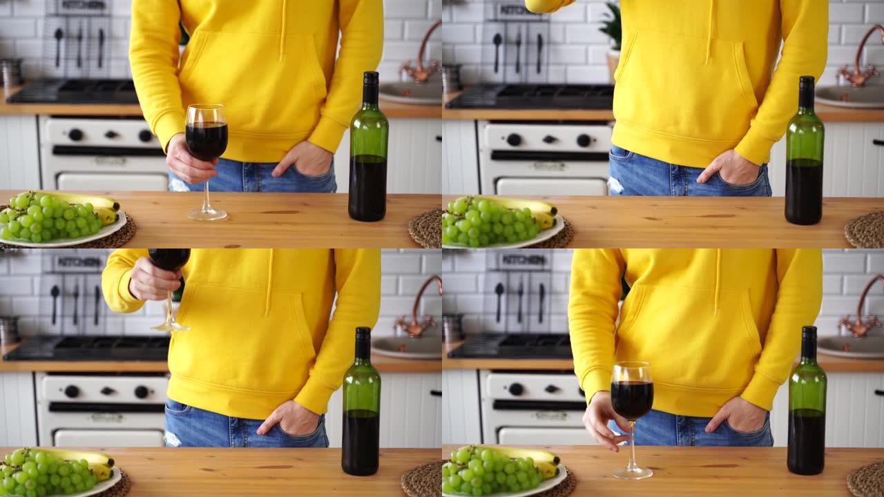 无法识别的人在厨房里喝红酒的特写镜头。未知男性拿玻璃和饮料