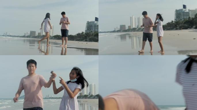 快乐的亚洲男孩和女孩一起在海滩上玩耍，同时在假期和家人一起放松，生活方式理念。