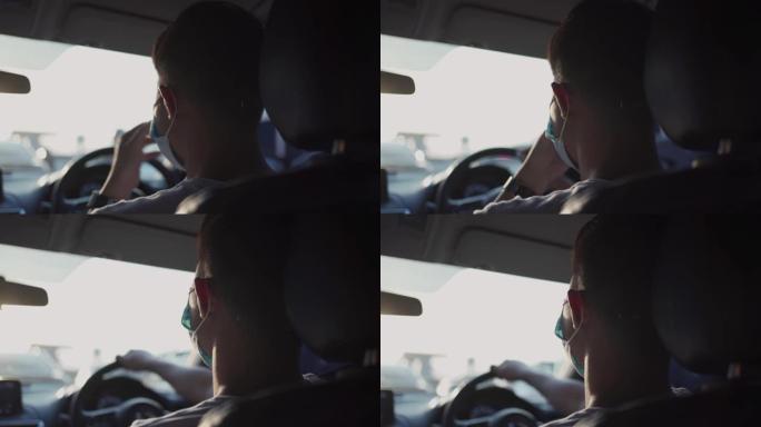 年轻的亚洲男性在车内行驶时戴上防护口罩，保护自己免受大流行，新常态生活，安全旅途，新型冠状病毒肺炎疾