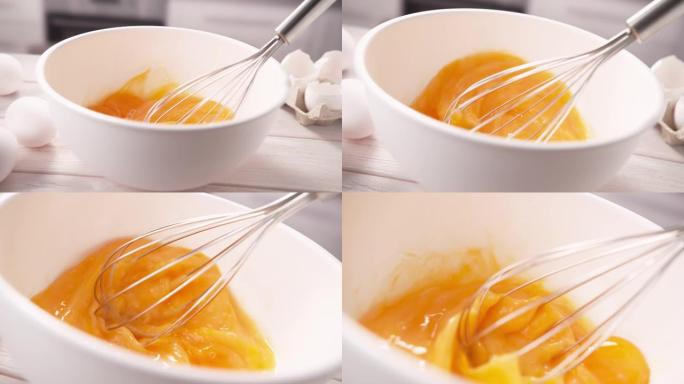 用打蛋器在白碗中搅拌蛋黄，以慢动作搅拌蛋卷