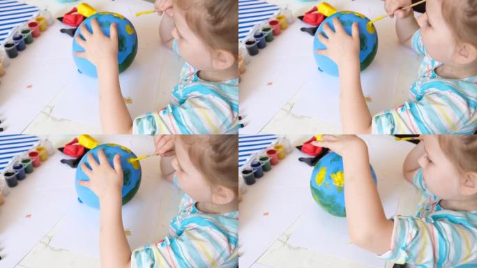 儿童在气球上绘制油漆图案。