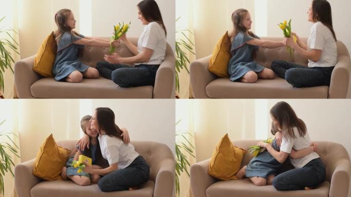女儿祝贺母亲母亲节，并送她鲜花和自制礼物。他们坐在家里的沙发上拥抱并大笑。母亲节，3月8日和生日概念