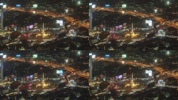 胜利纪念碑鸟瞰图的时间流逝，在繁忙的街道上有车灯步道。曼谷市中心天际线的环形交叉路口。泰国。智慧城市