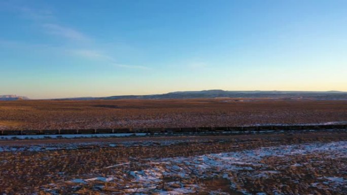 冬季日落时的沙漠和货运列车。美国犹他州。鸟瞰图