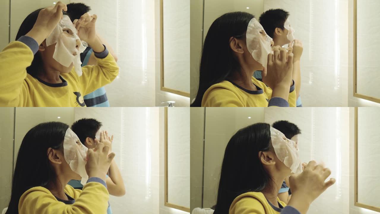 亚洲儿童在度假期间在酒店房间里打开面膜一起治疗面部，生活方式理念