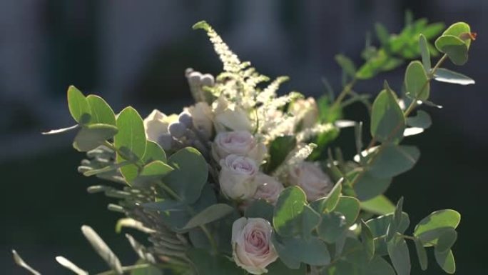 婚礼宴会期间，节日餐桌上摆放着一束玫瑰，落叶菊，cortaderia和桉树树枝