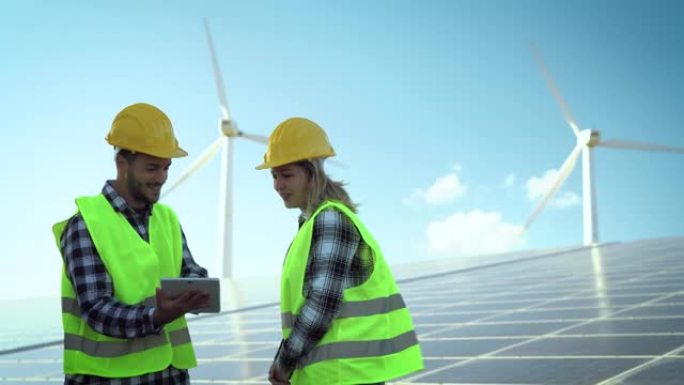 使用风力涡轮机和太阳能电池板为替代能源工作的人们-创新和绿色电力概念