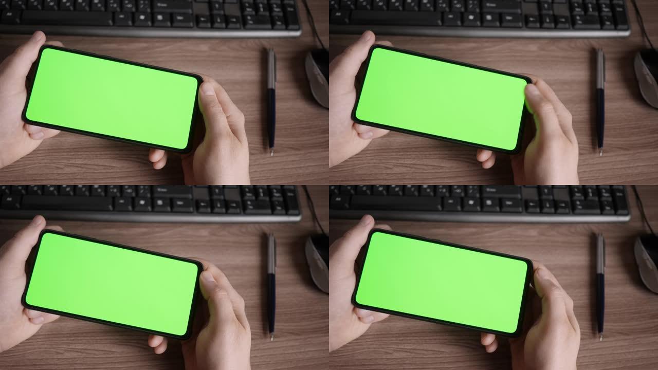 男子在水平模式下使用智能手机和绿色模拟屏幕，进行滑动，滚动手势。盖伊手机，互联网社交网络浏览新闻，财