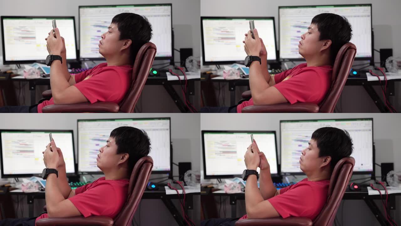 亚洲男人在用电脑工作时感到无聊。