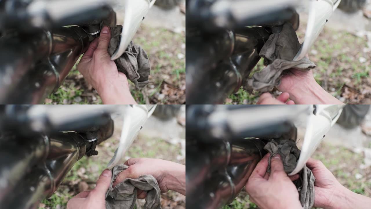 机械师的手在车库里拧摩托车的一些螺丝