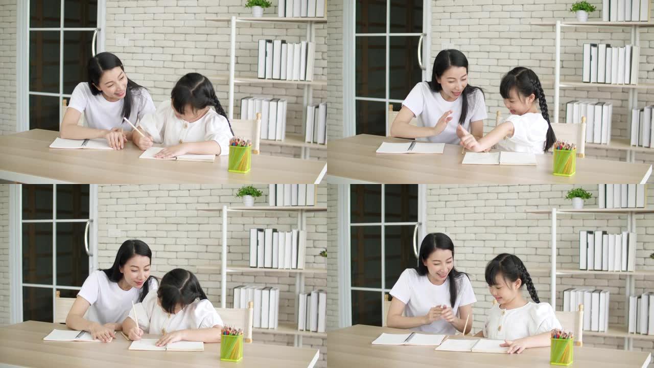 年轻的母亲给孩子做功课和解释作业，在家学习