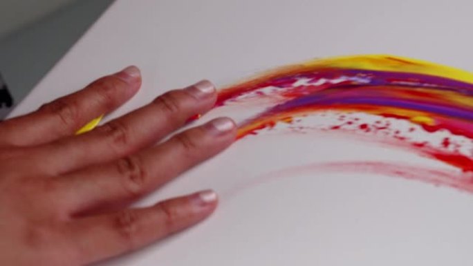 女艺术家用手作为画笔在白色画布上涂上颜色