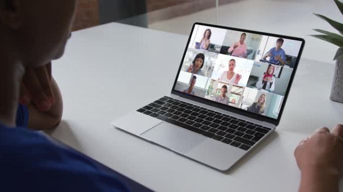 非裔美国妇女在笔记本电脑上与办公室同事在家中进行视频会议