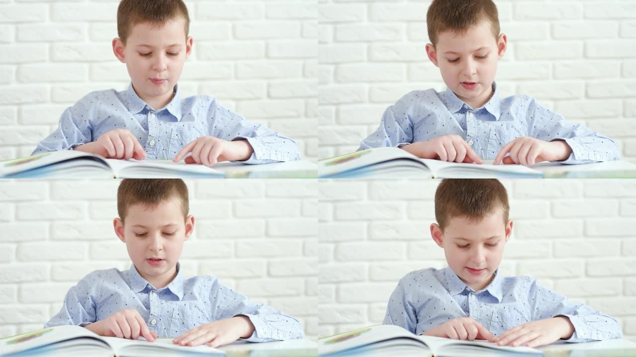 小学生孩子在白砖背景上的白色桌子旁看书