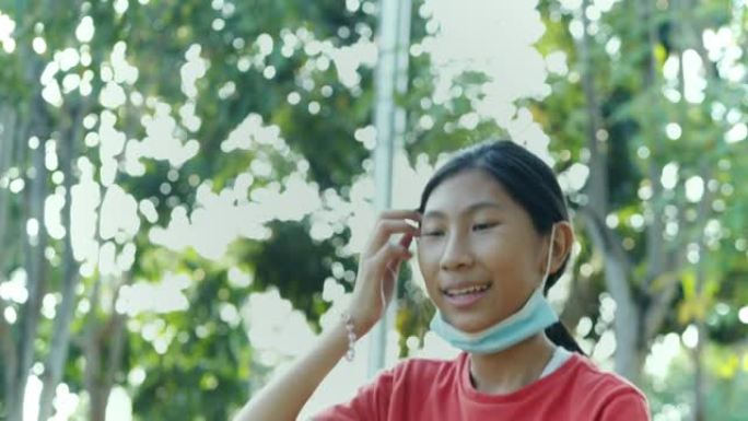 快乐的亚洲女孩在操场上玩跷跷板，生活理念。