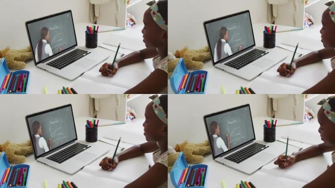 非裔美国女孩在家里用笔记本电脑与女老师进行视频通话时正在做作业