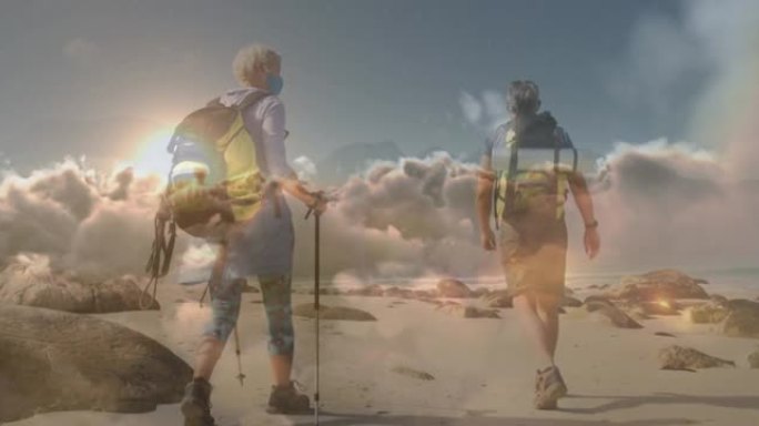 快乐的高加索高级夫妇戴着口罩在快速移动的云层上在海岸徒步旅行