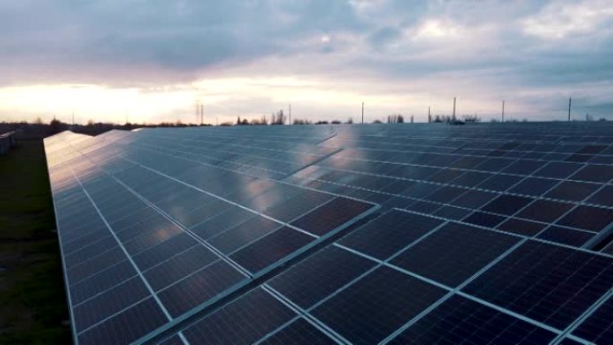 日出前的太阳能光伏鸟瞰图。光伏板系统。绿地上的太阳能农场。拥有许多太阳能电池板的现代综合体。替代能源